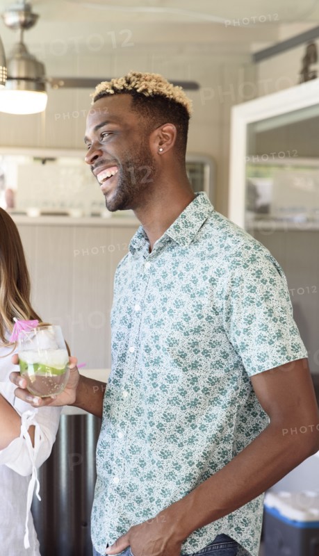 Man holding cold drink laughing outdoors