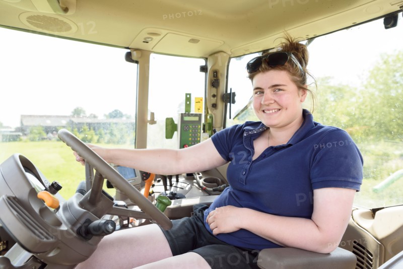 Portrait of smiling Caucasian woman driving tractor