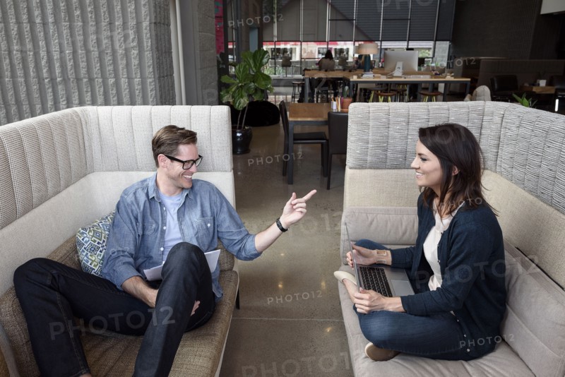 Caucasian couple sitting on sofas talking