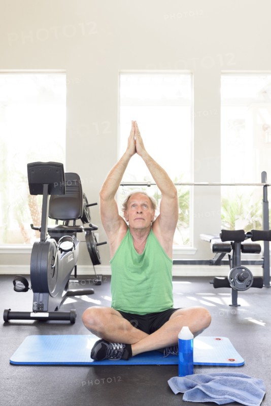 Caucasian man practicing yoga in gymnasium