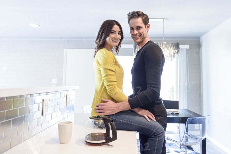 Portrait of Caucasian couple embracing on kitchen counter