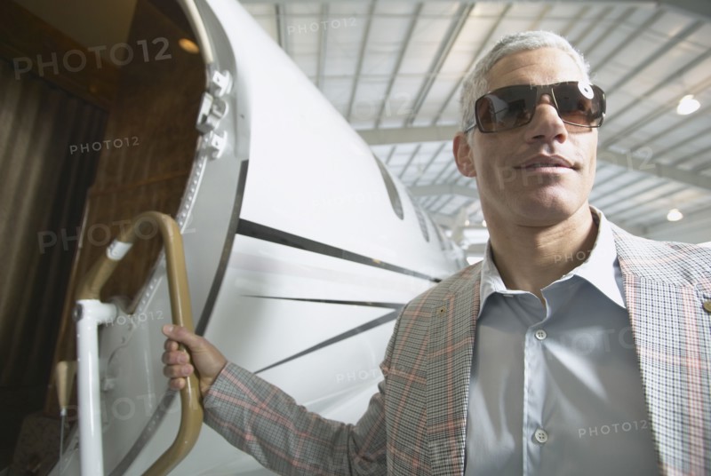 Middle-aged man boarding airplane in hanger