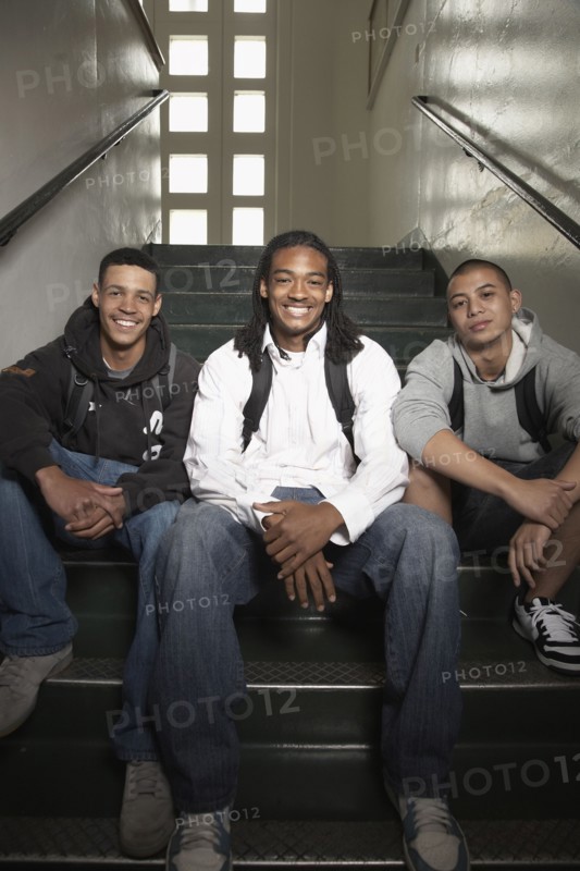 Group of young men sitting on stairs at school