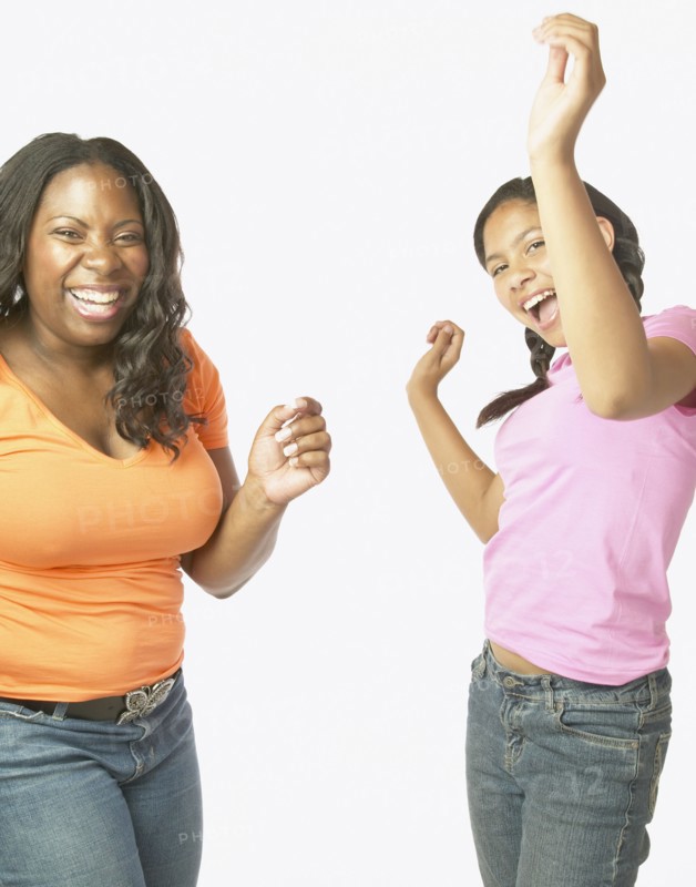 Studio shot of African mother and daughter dancing and laughing