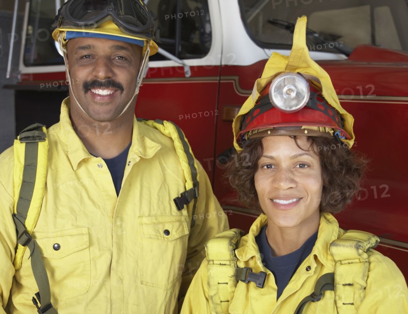 Two African firefighters next to fire truck