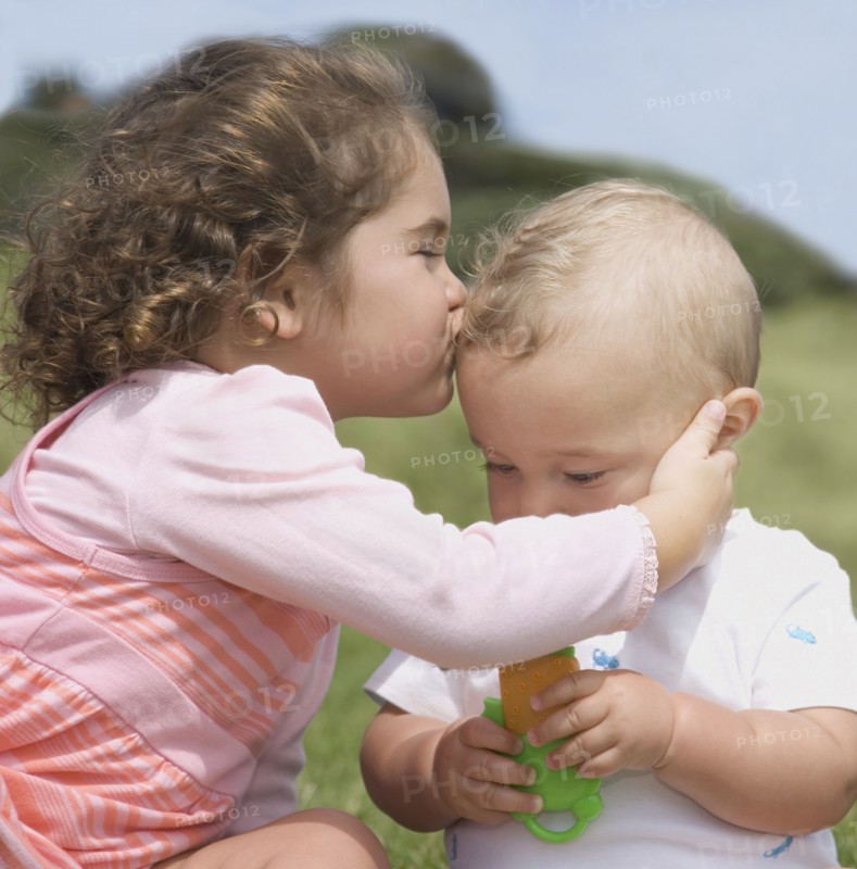 Hispanic girl kissing baby