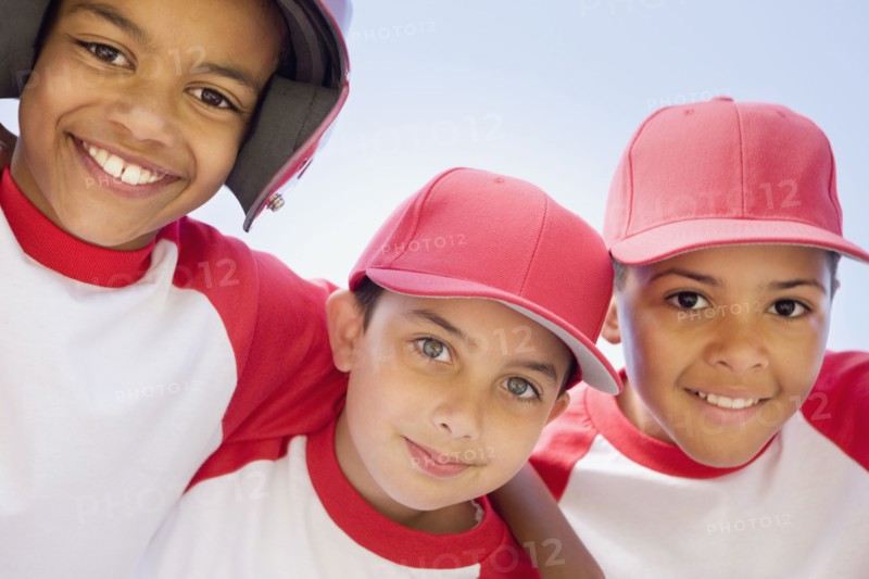 Multi-ethnic boys in baseball uniforms hugging