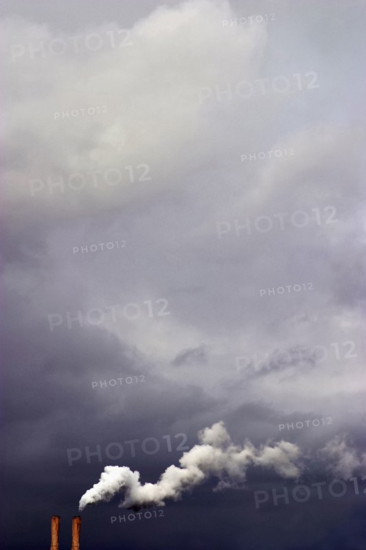 Overcast sky and smoke stacks billowing smoke