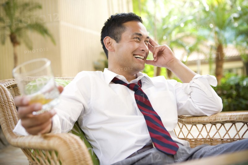 Smiling mixed race man drinking on patio