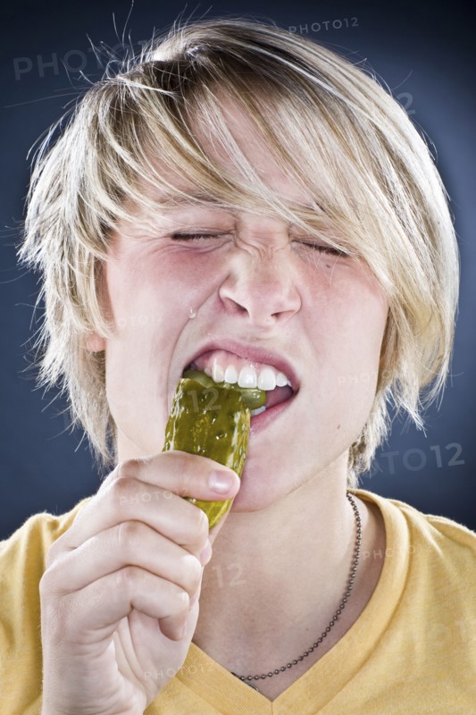 Caucasian boy eating pickle