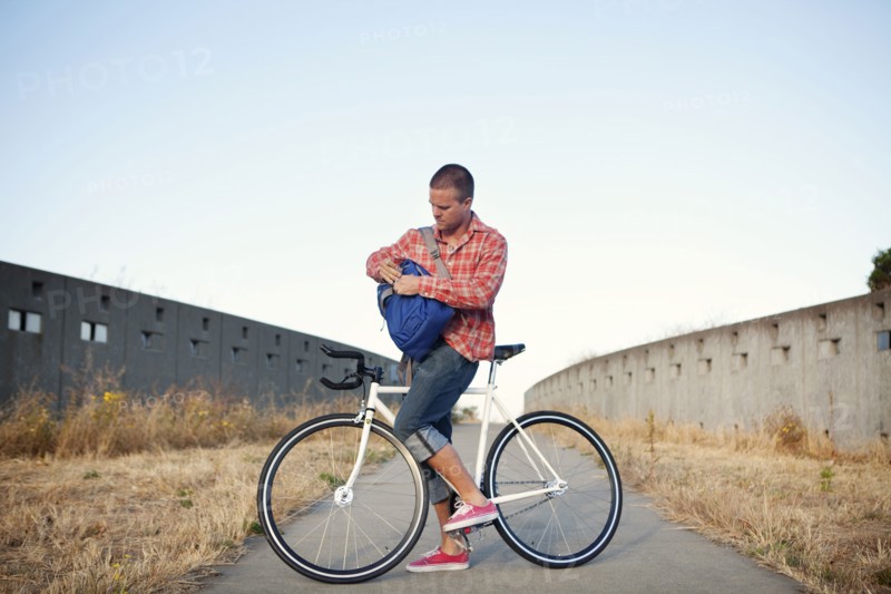 Bicycle messenger stopping on urban path