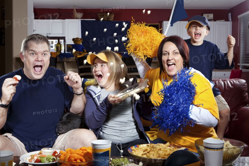 Cheering Caucasian family watching sports