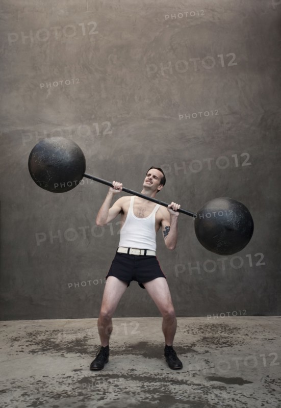 Skinny Caucasian weight lifter straining