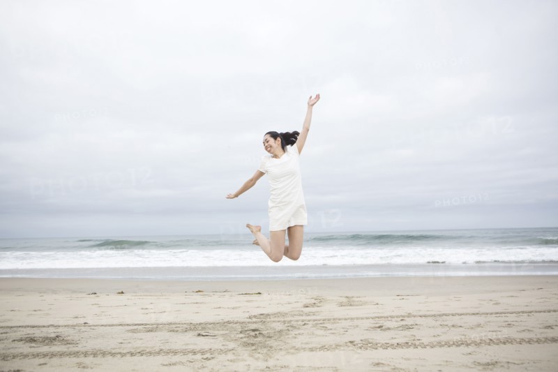 Woman jumping for joy on beach