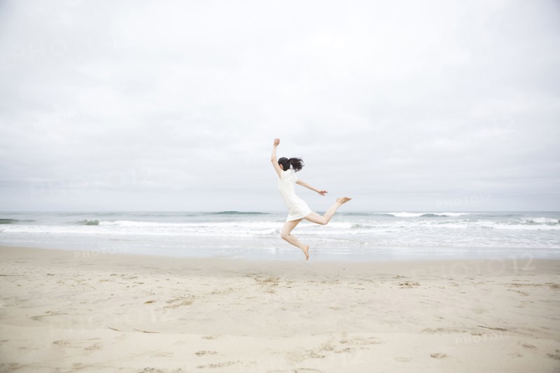 Woman jumping for joy on beach