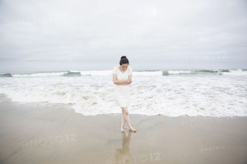Woman standing near waves on beach