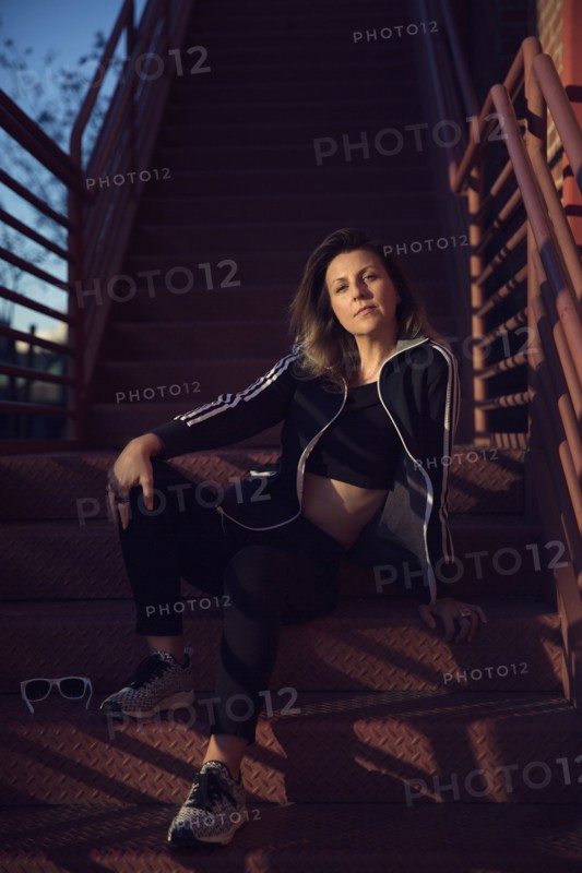 Portrait of Caucasian woman resting on metal staircase