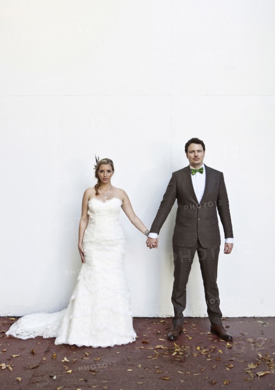 Serious Caucasian bride and groom holding hands