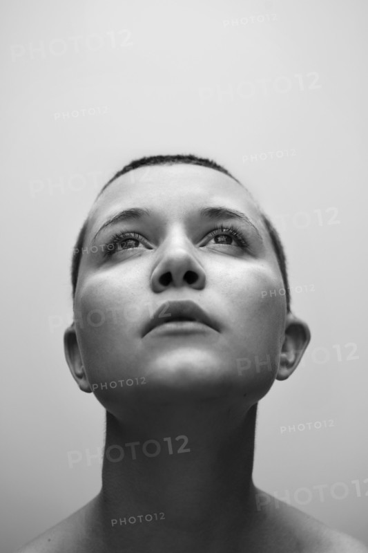 Caucasian woman with shaved-head looking up