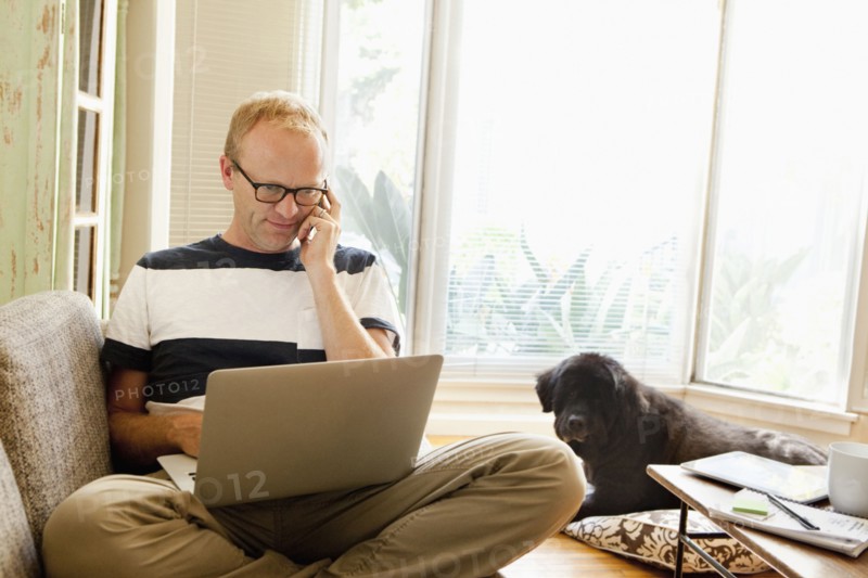 Caucasian man using laptop on sofa