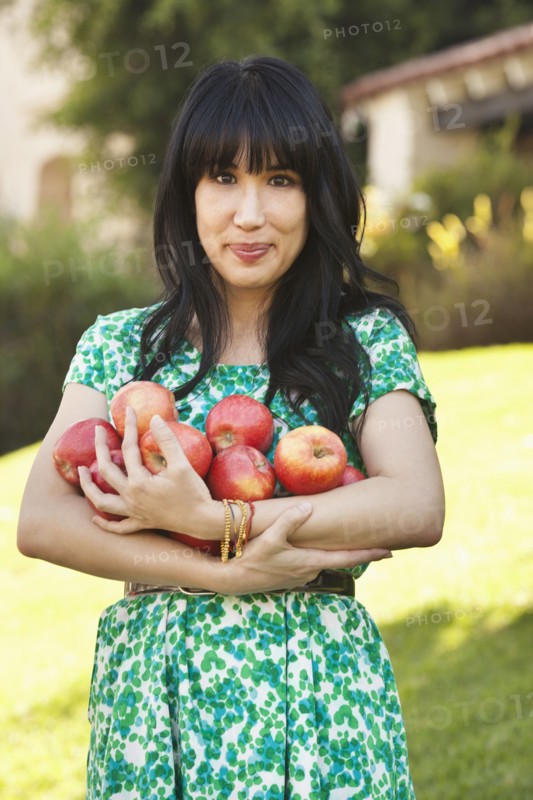 Woman holding armfuls of fruit