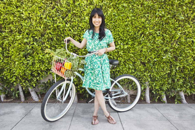Woman carrying produce in bicycle basket