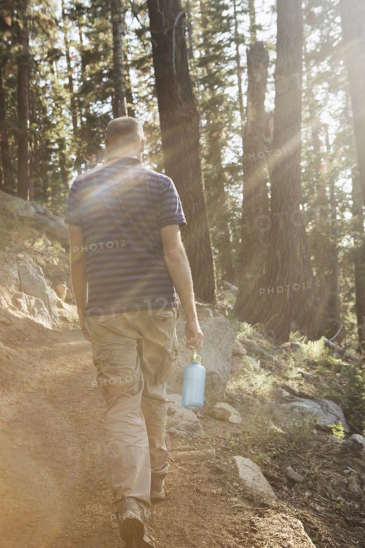 Man hiking on dirt trail in forest