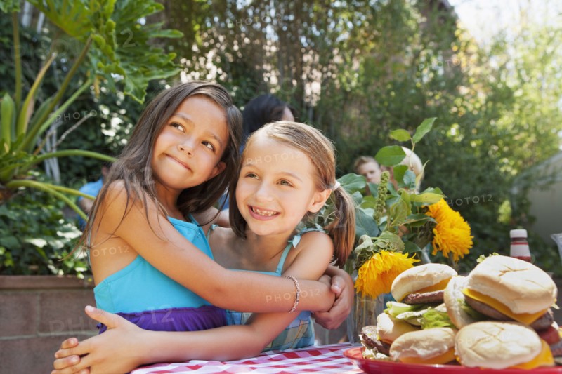 Girls hugging at backyard barbecue