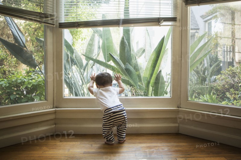 Baby boy looking out window