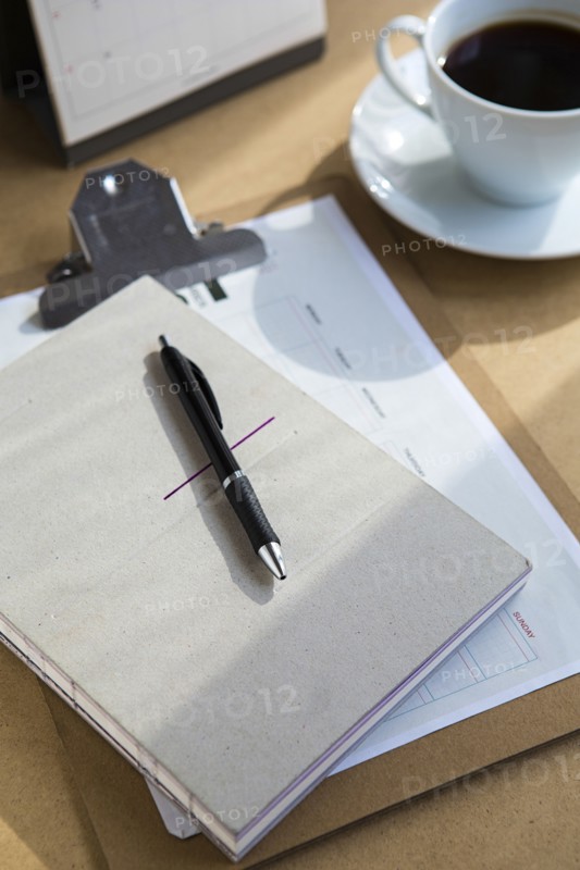 Tablet computer on table with books and cup of coffee