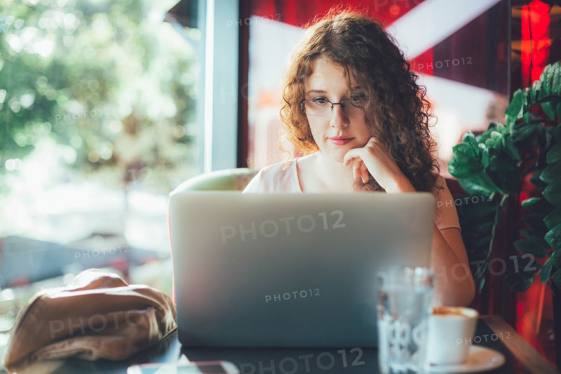Woman using laptop computer in cafe