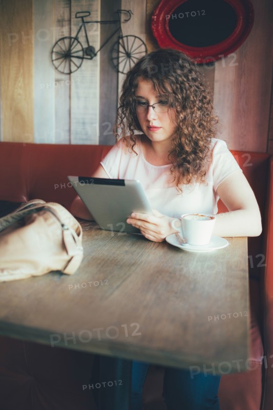 Woman using digital tablet in cafe