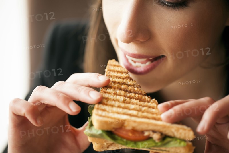 Close up of woman eating sandwich