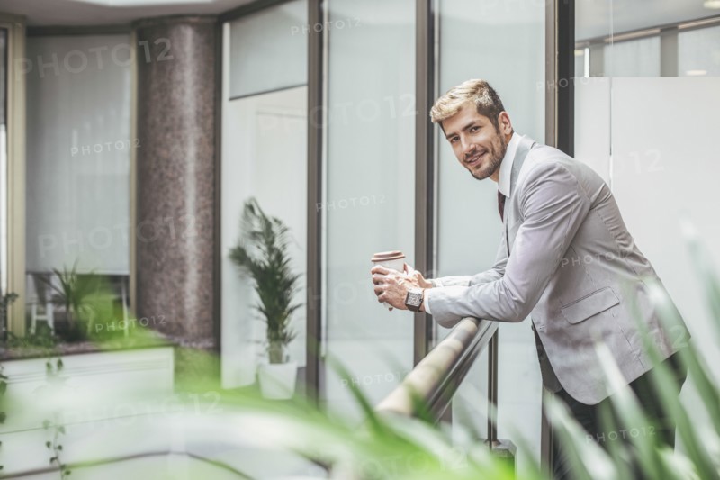 Caucasian businessman drinking coffee on office balcony