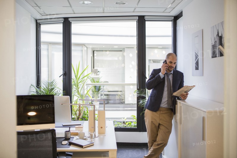 Caucasian businessman talking on cell phone in office