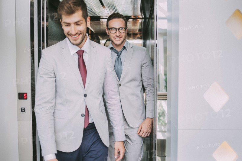 Caucasian businessmen walking out of elevator