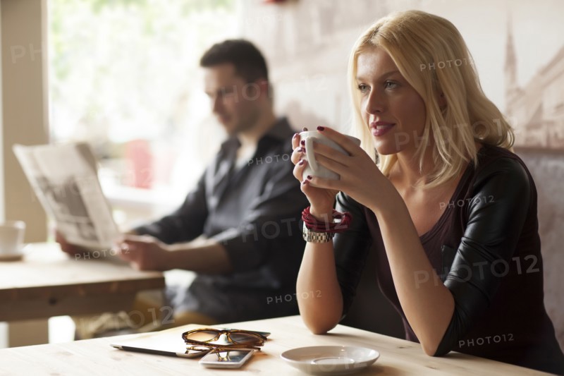 Woman drinking cup of coffee in cafe