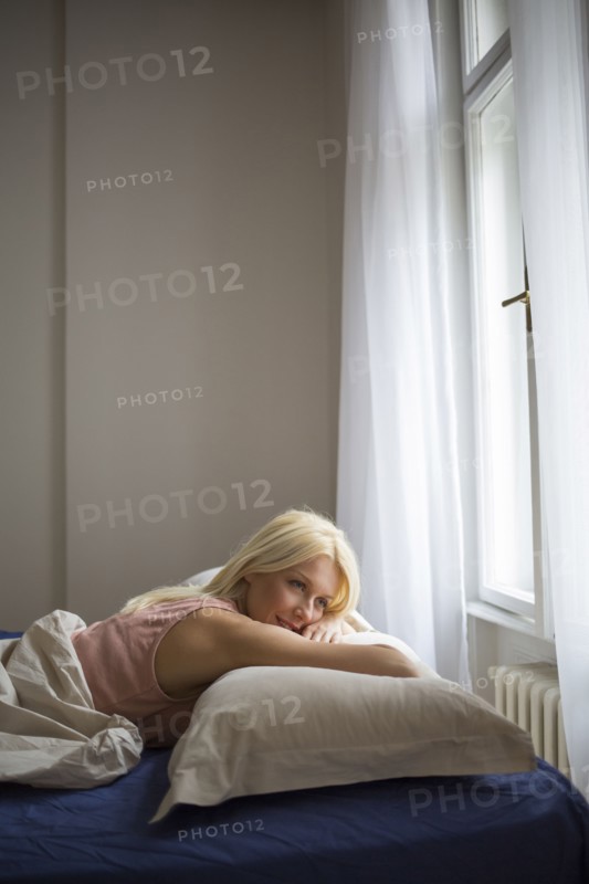 Smiling woman laying in bed