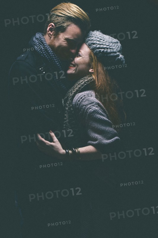 Smiling couple wearing warm clothing hugging