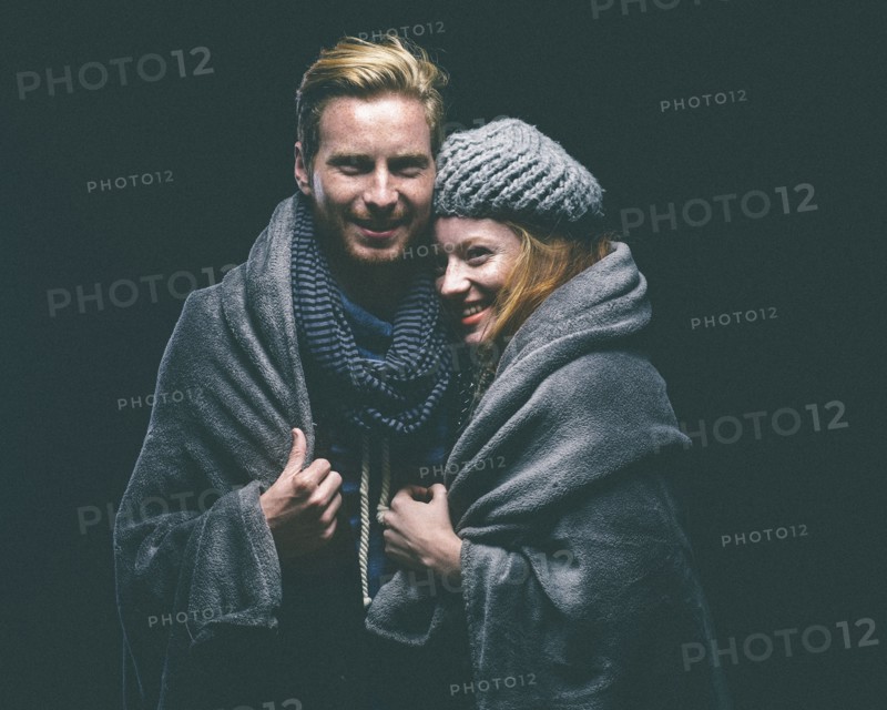 Smiling couple wrapped in blanket