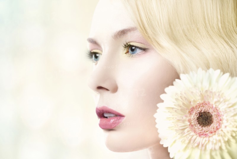 Caucasian woman with pink lipstick wearing white flower
