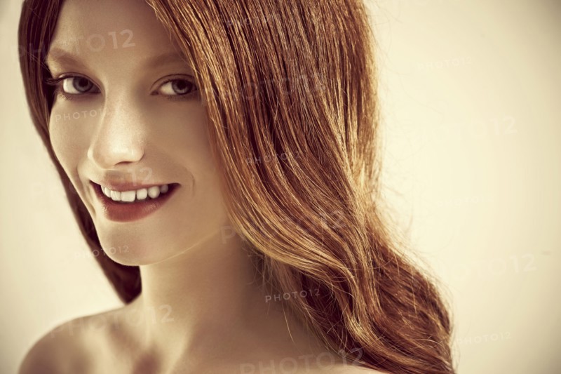 Close up of smiling woman with long red hair