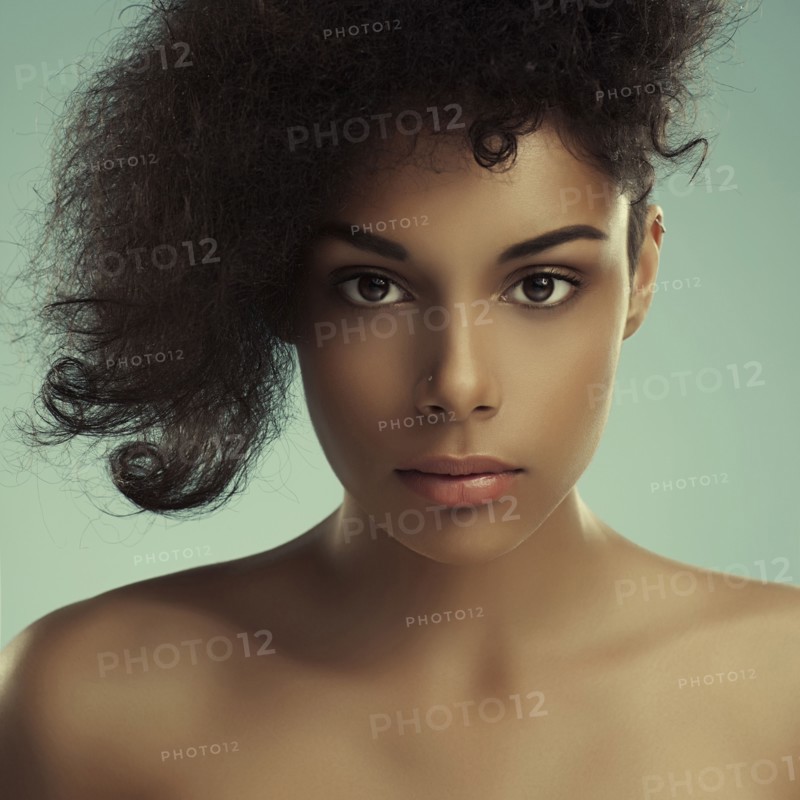 Close up of serious curly-haired woman