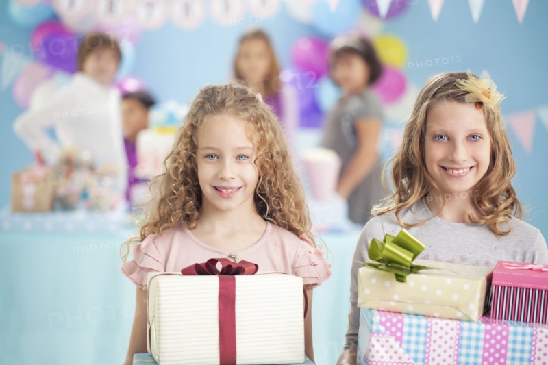 Girls holding wrapped gifts at birthday party