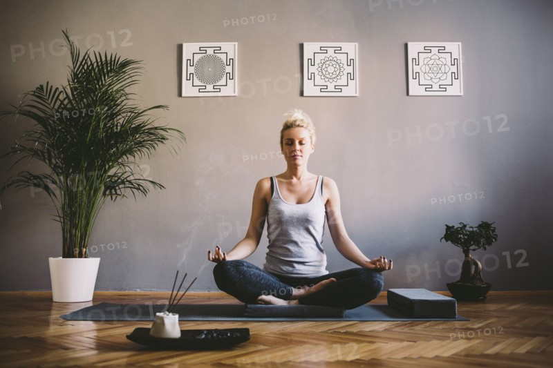 Caucasian woman meditating in yoga studio