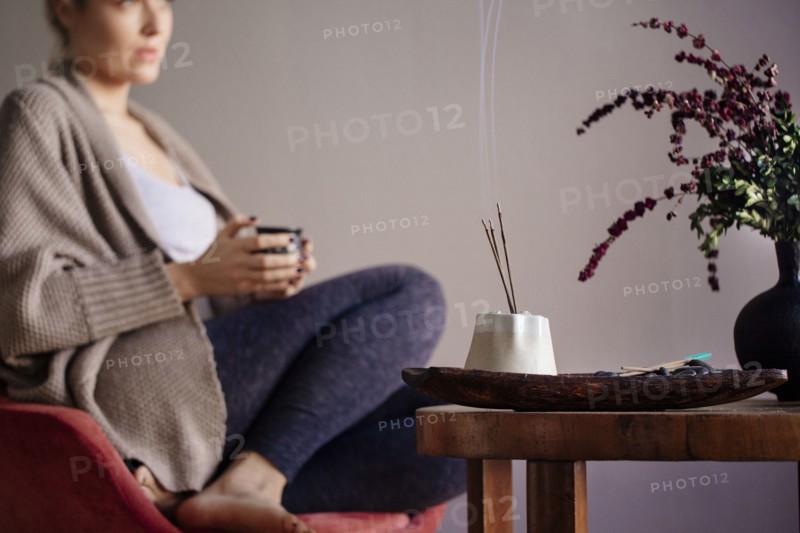 Caucasian woman burning incense in living room