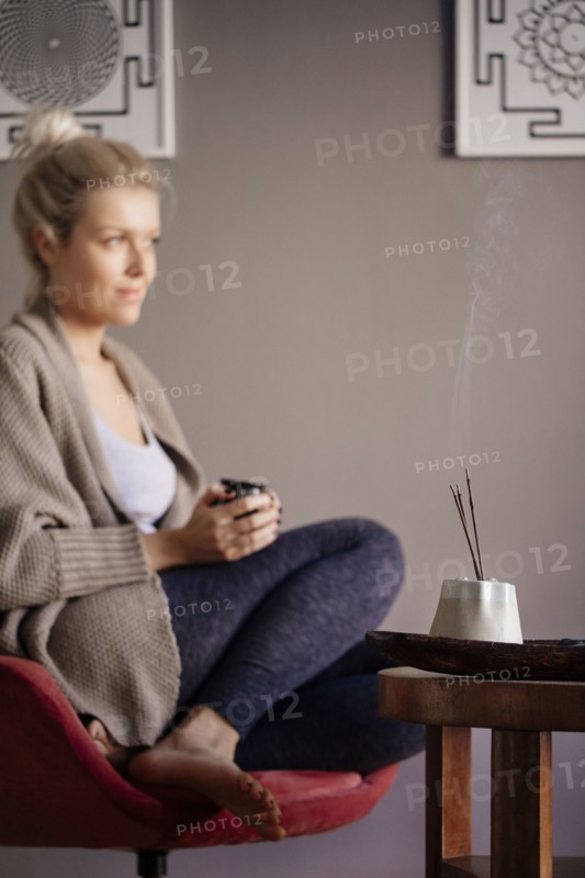 Caucasian woman burning incense in living room