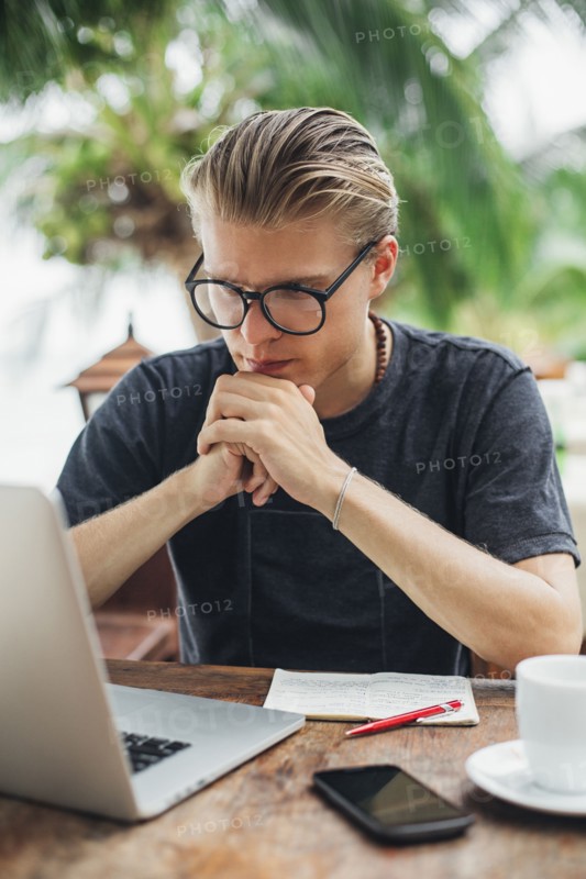 Caucasian man using laptop in cafe
