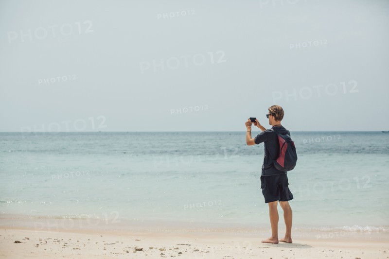 Caucasian man photographing seascape