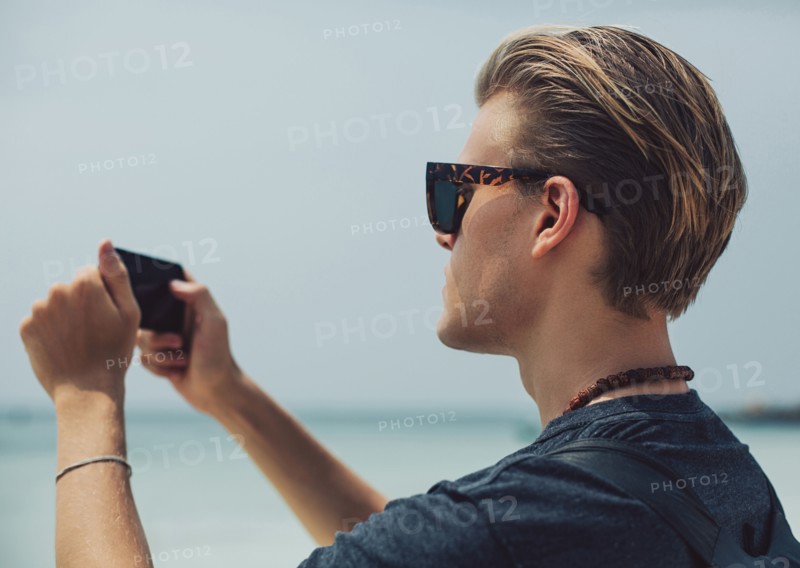 Caucasian man photographing seascape